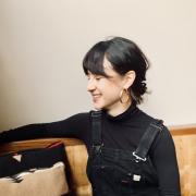 A photo of a person with bangs wearing overalls