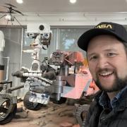 headshot of man with mars rover